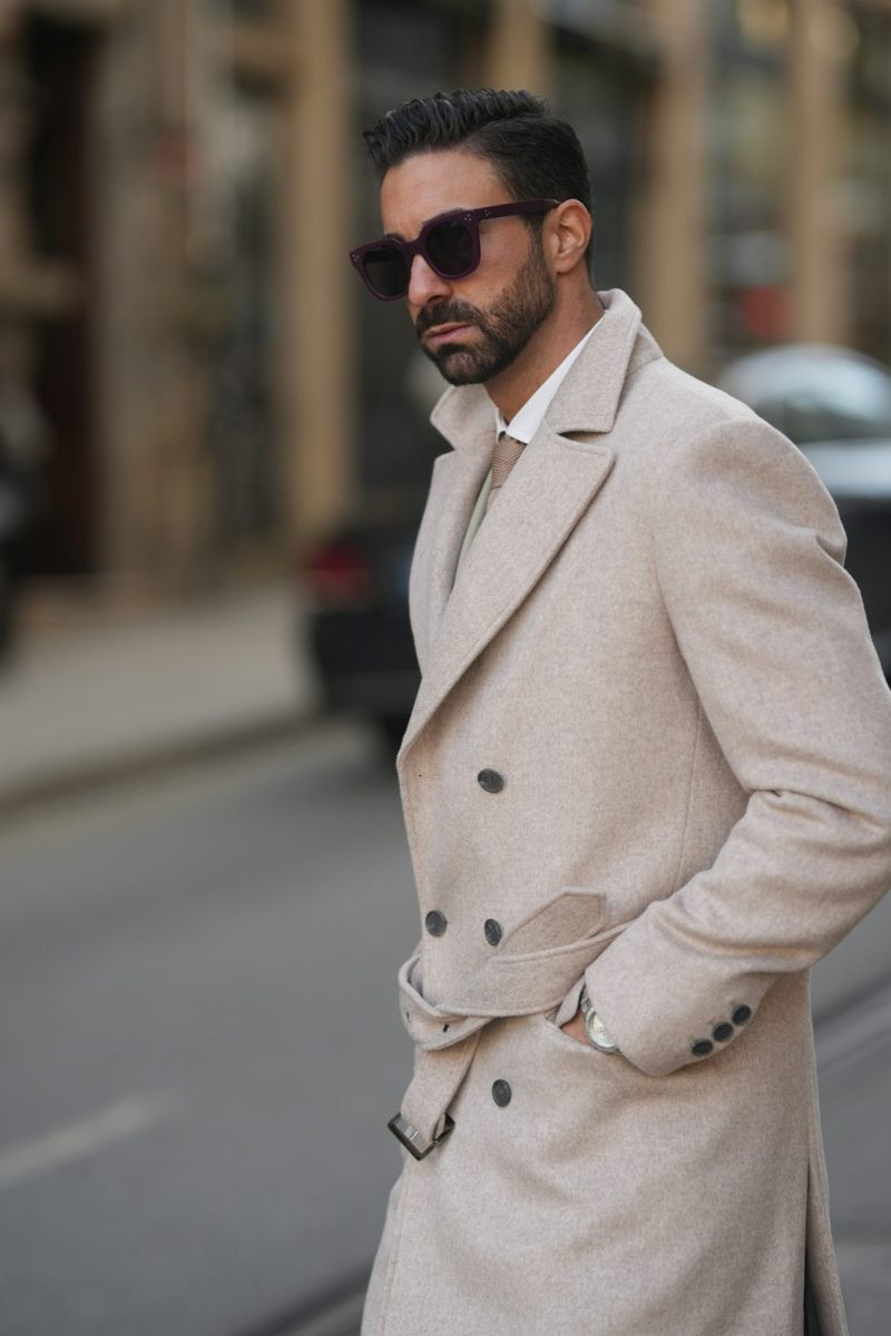 Man in a light stone belted trench coat