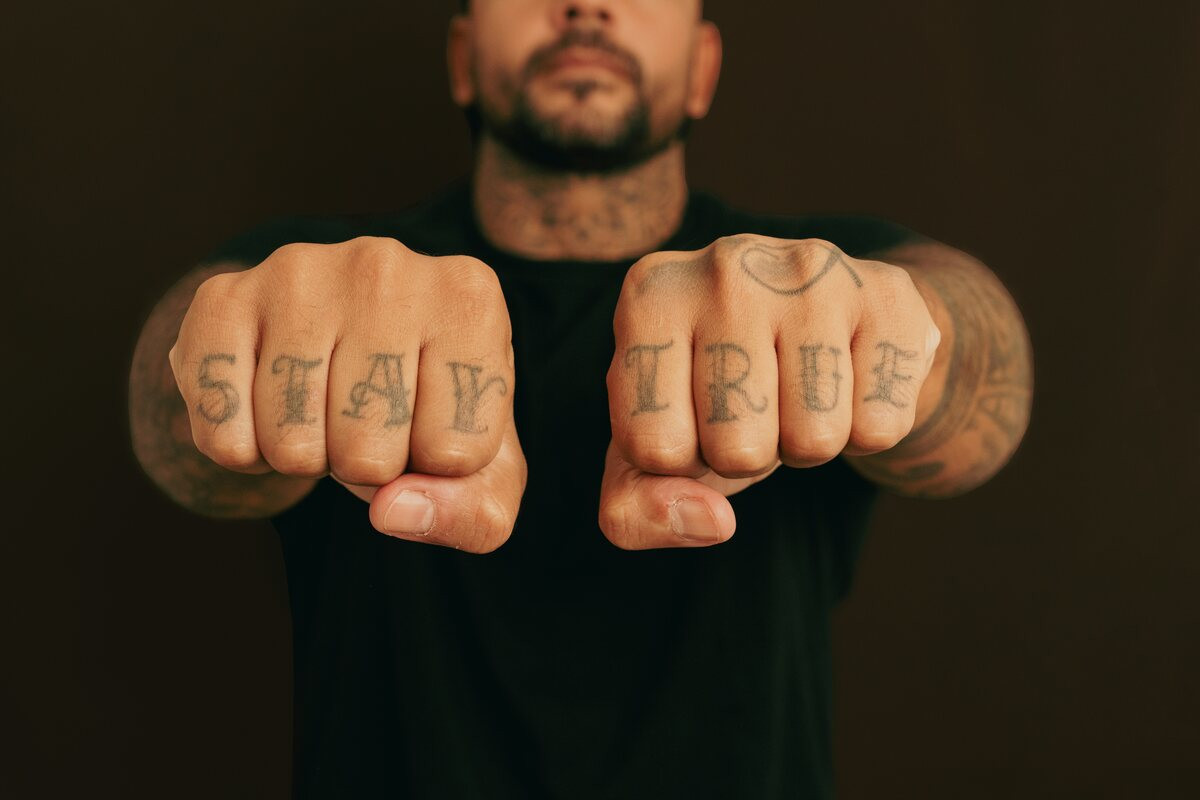 Man holding out both fists with STAY TRUE knuckle lettering