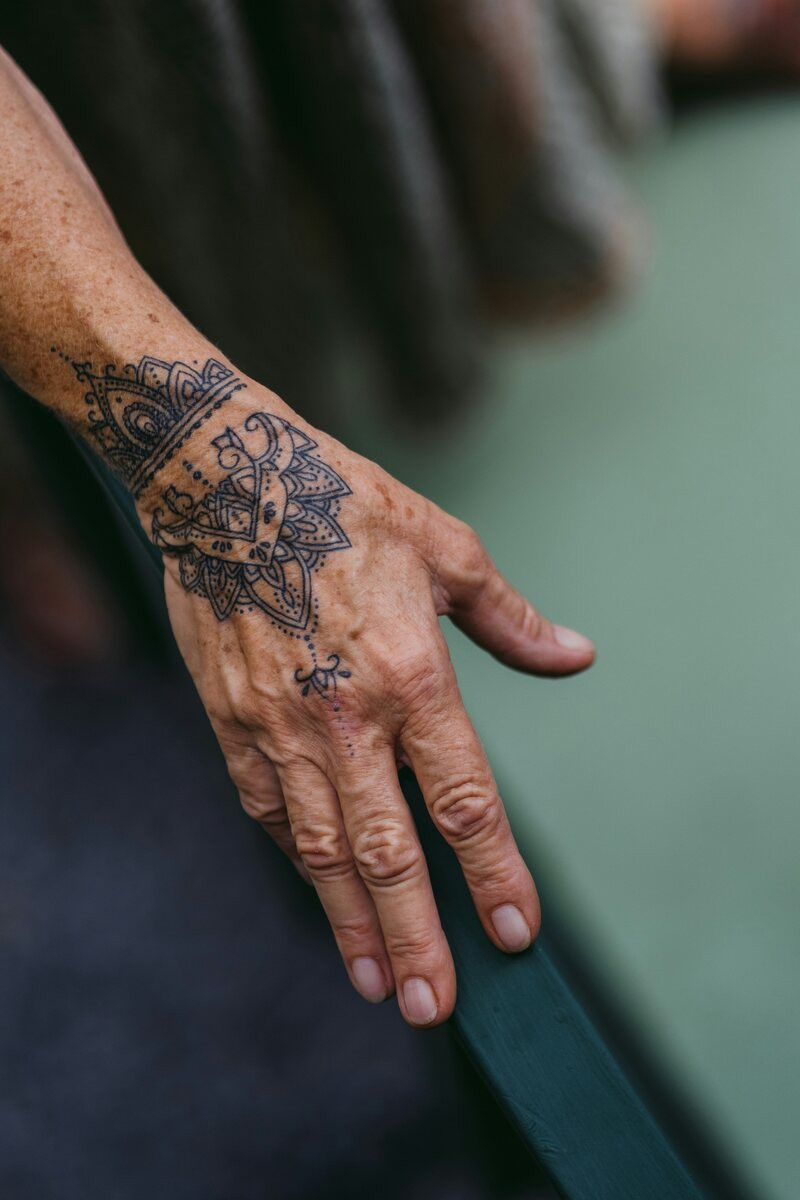 Weathered hand with ornamental floral tattoo work